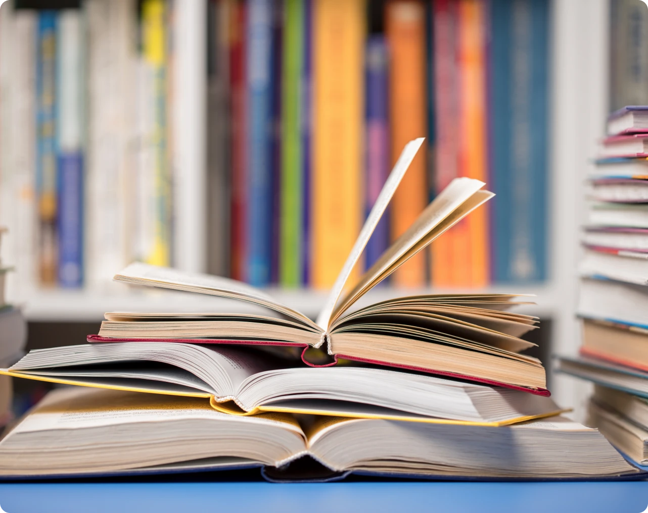 Open books stacked in front of bookshelf